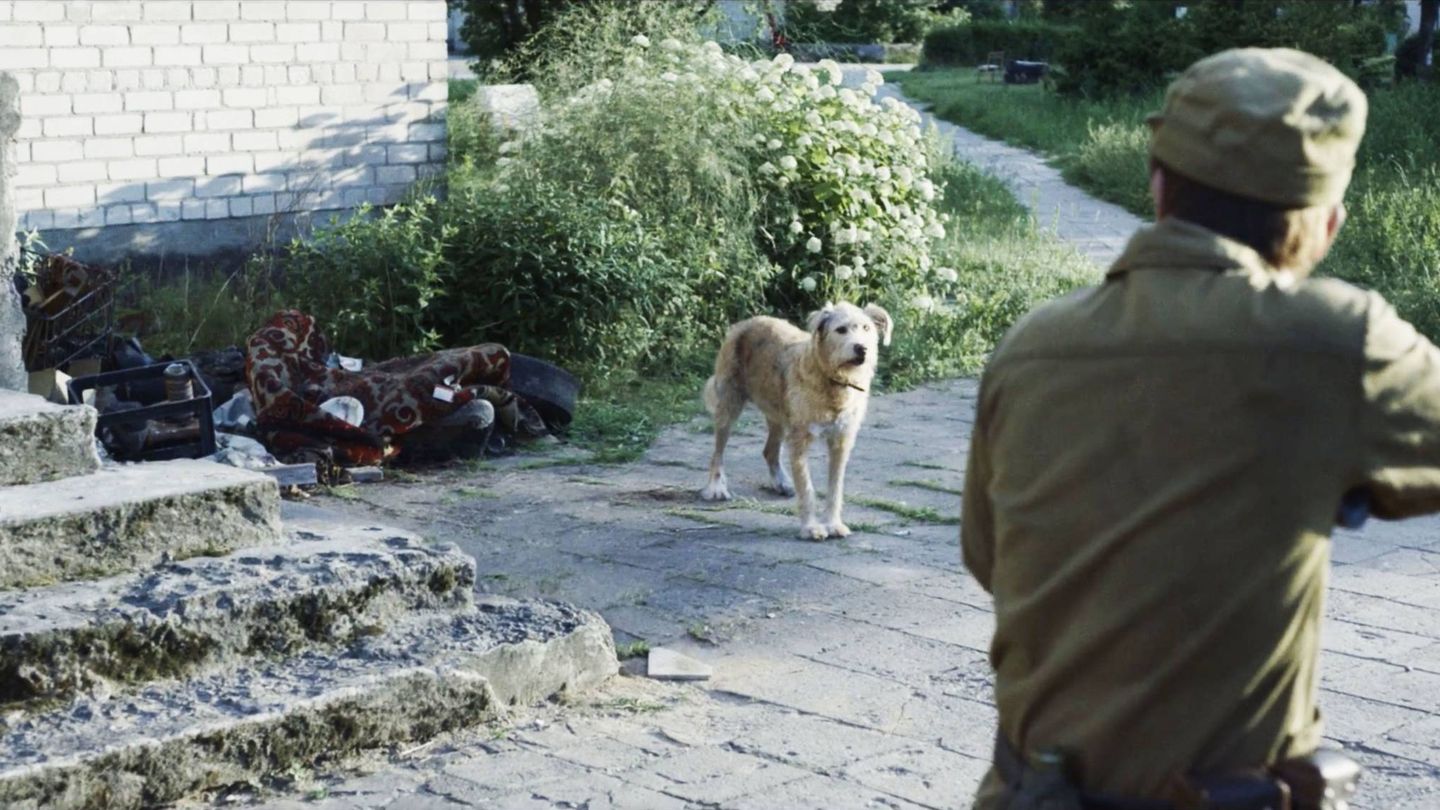 Un joven, a punto de sacrificar a un perro en 'Chernobyl'. (HBO)