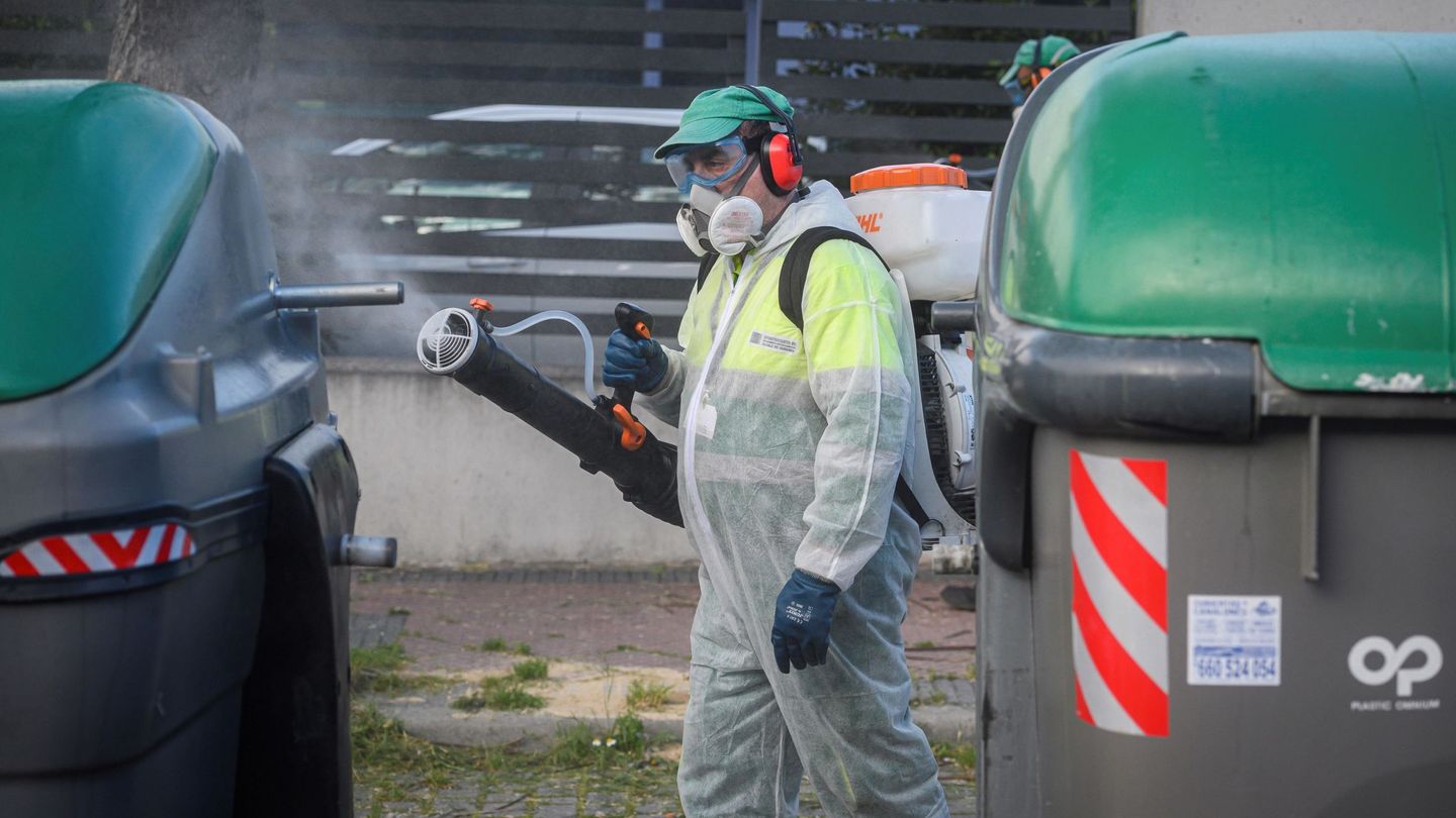 Un operario desinfecta unos contenedores de basura. (EFE/Fernando Villar)
