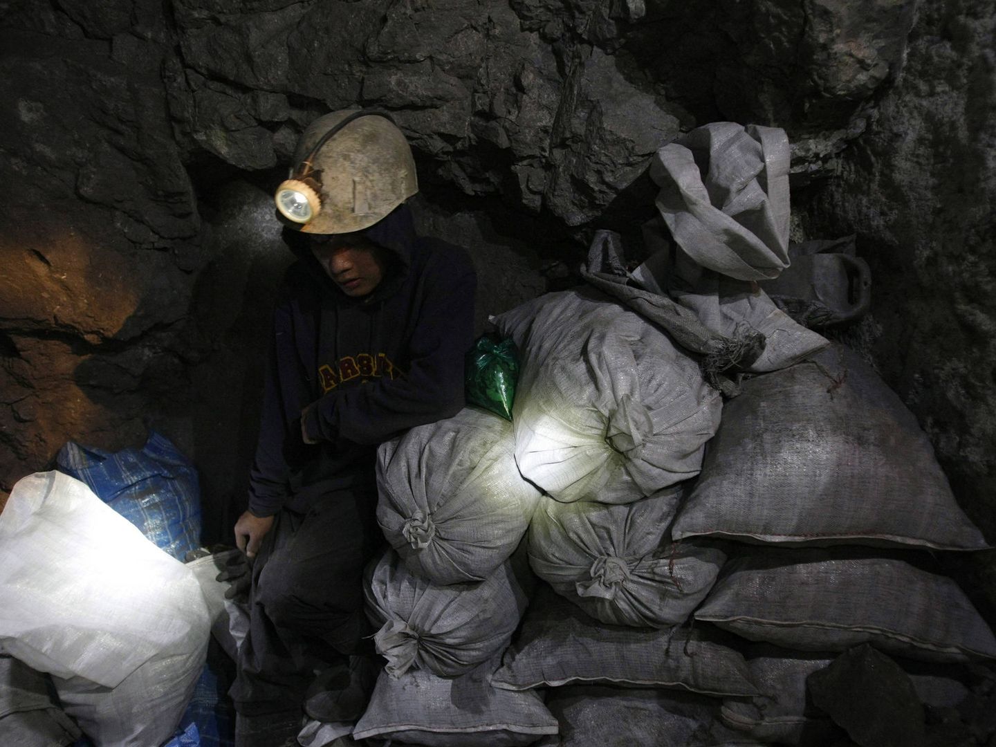 Moisés, un joven minero de 17 años, guarda sacas de mineral en la mina de El Rosario en Cerro Rico, en enero de 2010. (Reuters)