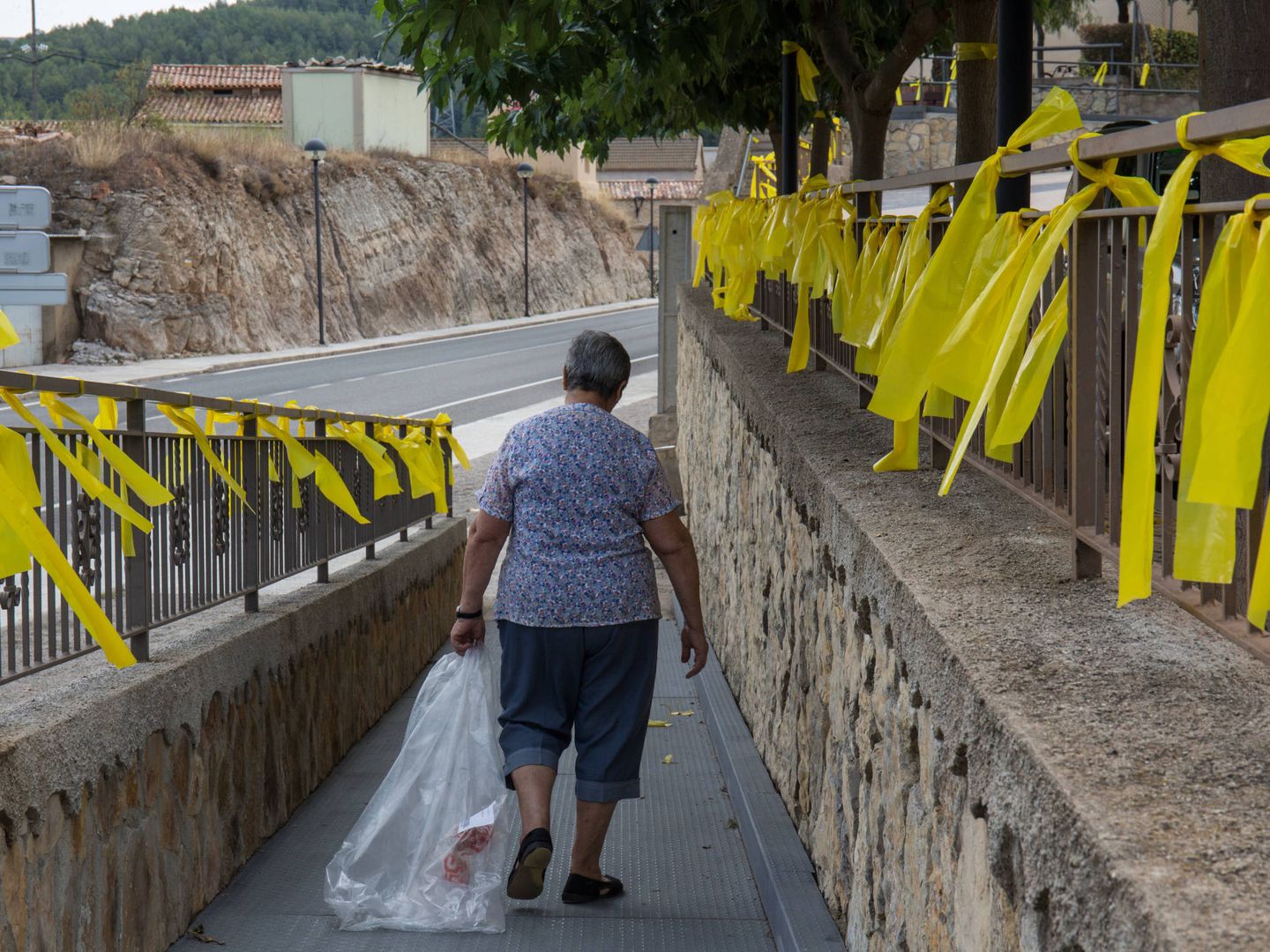 Una mujer camina rodeada de lazos en Vandellòs (Tarragona). (D. B.)