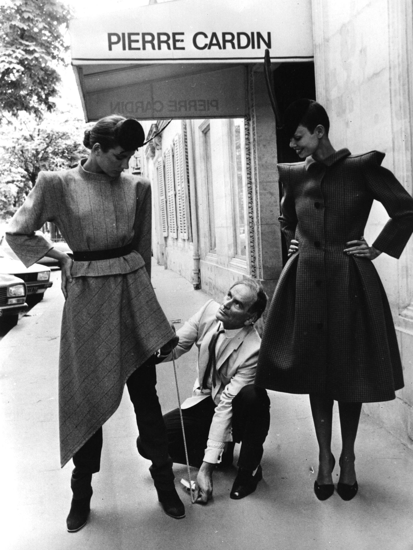 El diseñador Pierre Cardin probando sus diseños a dos modelos a la entrada de su boutique en París ( Keystone / Getty Images)