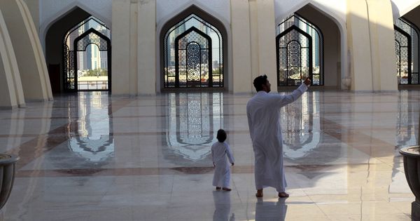 Foto: Un qatarí y su hijo en la mezquita del Imam Muhammad ibn Abd al-Wahhab, en Doha. (Reuters)