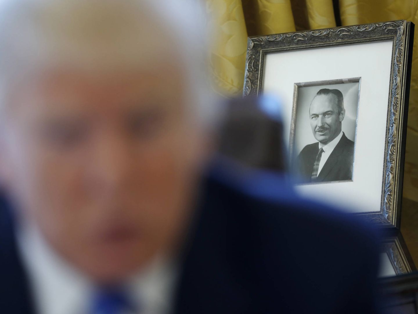 Una foto del difunto Fred Trump detrás del presidente durante una entrevista en el Despacho Oval de la Casa Blanca. (Reuters)