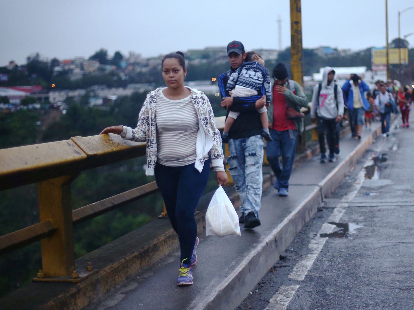 Integrantes de la caravana cruzan un puente a pie en Ciudad de Guatemala, el 18 de octubre de 2018. (Reuters)