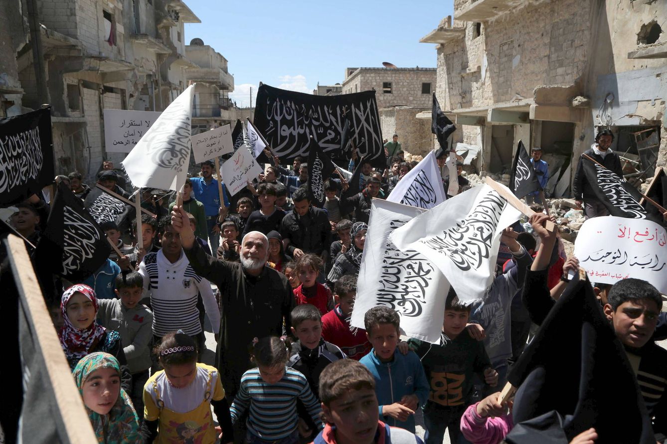 Residentes del barrio Al-Sakhour de Alepo sostienen banderas de Al Nusra para celebrar la toma de Idlib, el 24 de abril de 2015 (Reuters).