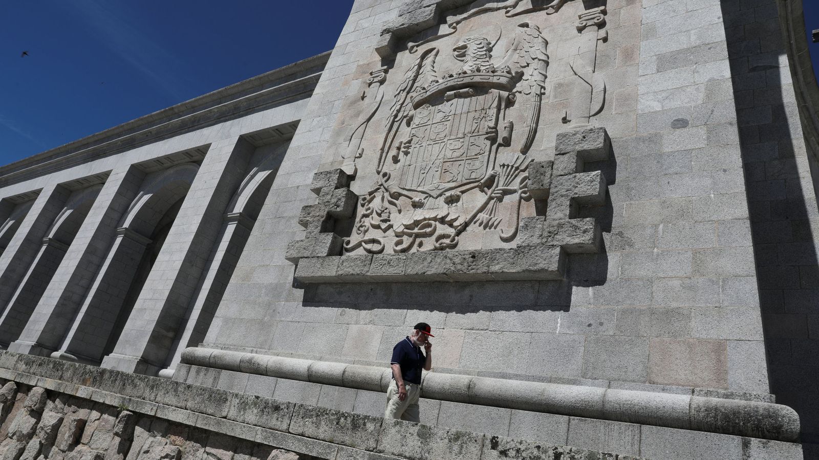 Foto: Un hombre pasea bajo un escudo franquista en el Valle de los Caídos, el pasado 19 de junio. (Reuters)