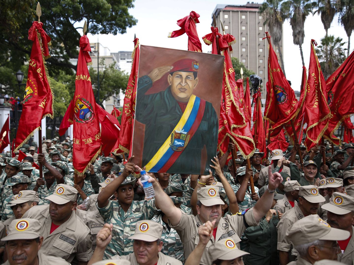 Efectivos venezolanos con un cartel del difunto presidente Hugo Chávez, en Caracas. (Reuters)
