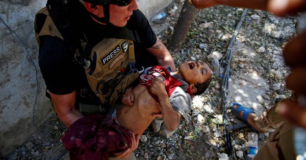 Foto: Un soldado da agua a un niño deshidratado rescatado por el Ejército iraquí en el frente de Mosul. (Reuters)