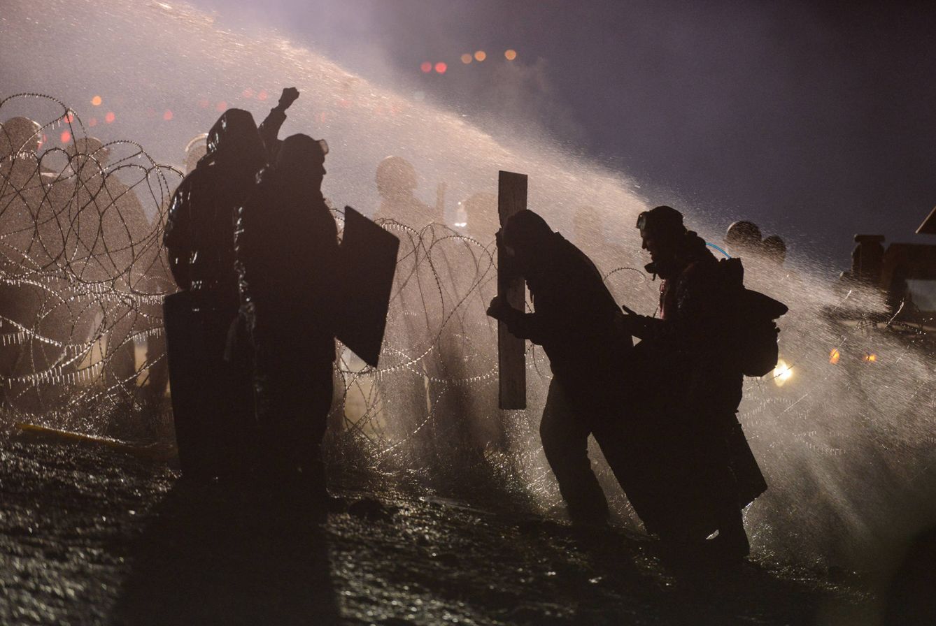 La Policía usa cañones de agua contra los manifestantes durante protestas contra el proyecto petrolero, en Dakota del Norte (Reuters).