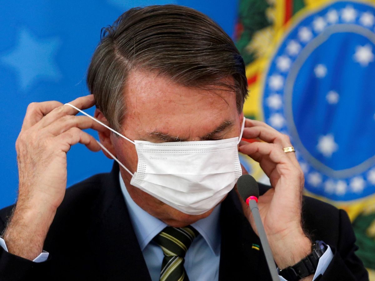 Foto: Bolsonaro poniéndose una mascarilla. (Reuters)