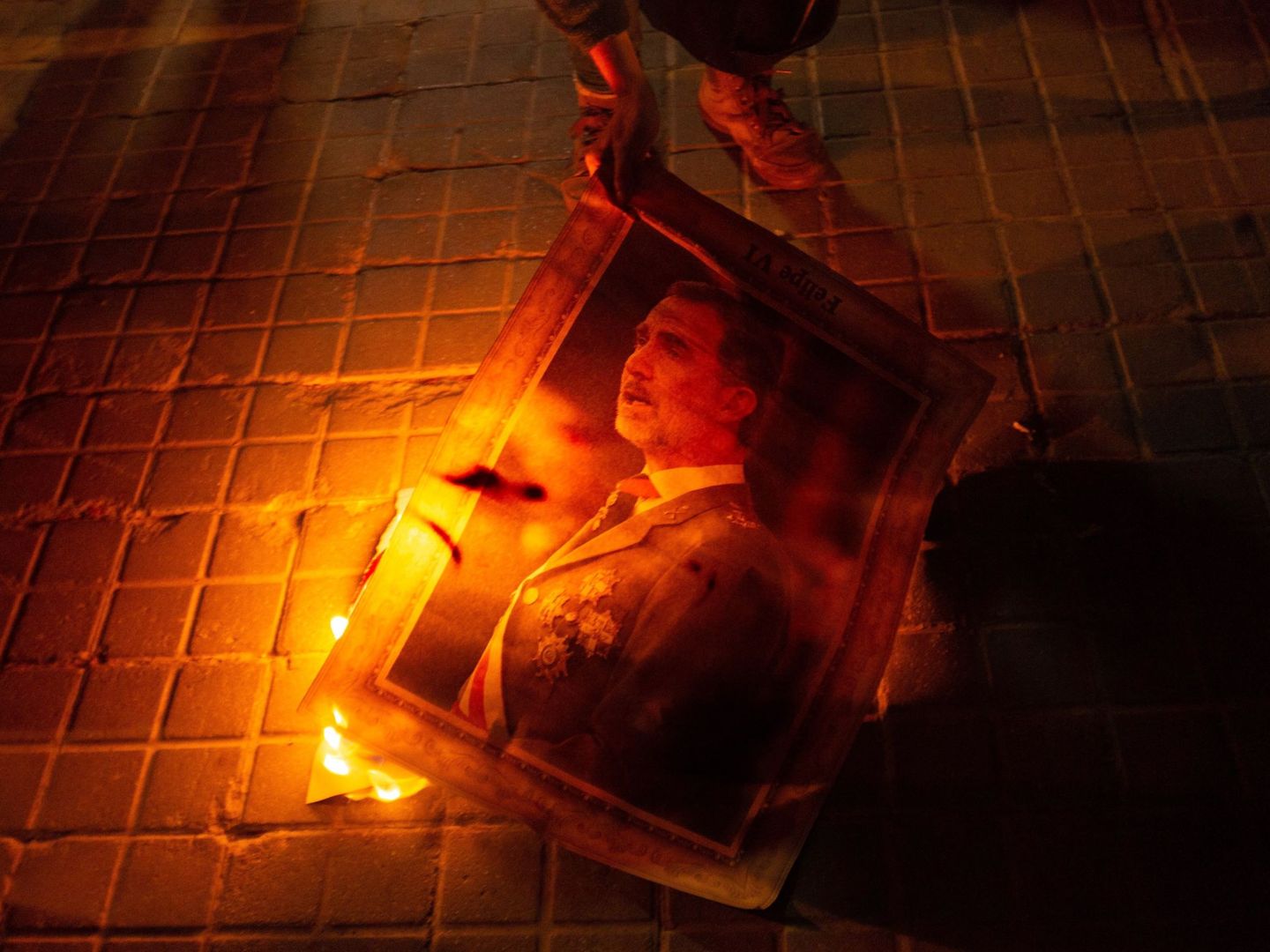 Manifestantes queman la foto de Felipe VI en Barcelona. (EFE)