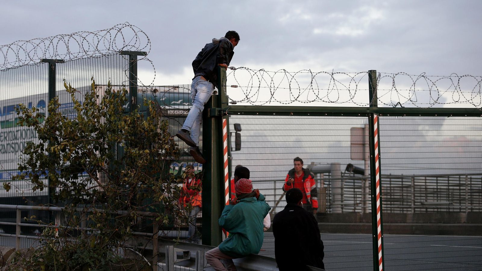 Foto: Un migrante salta una cerca antes de intentar tomar un tren en su ruta hacia Inglaterra, en la localidad francesa de Calais. (Efe)