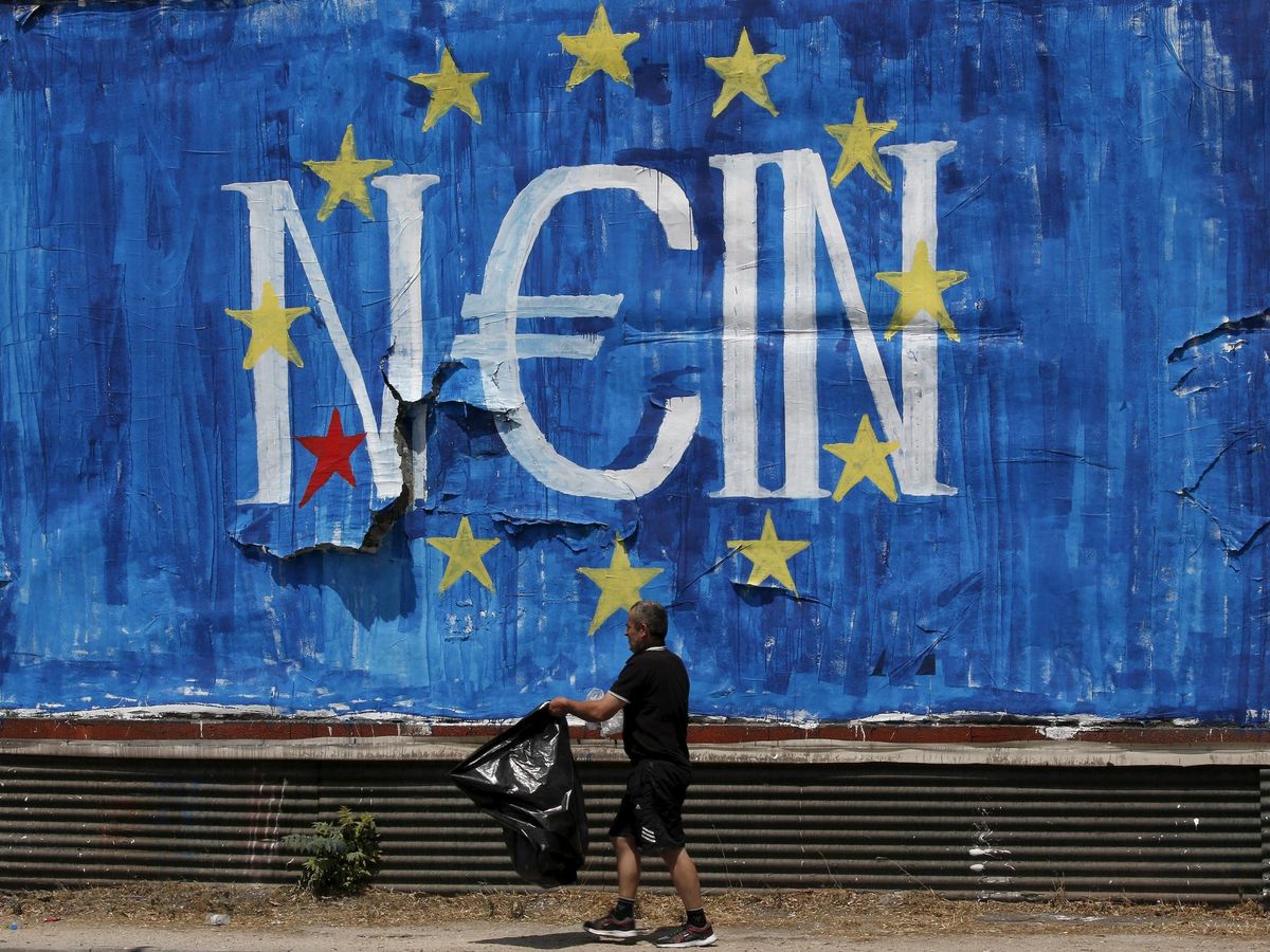 Foto: Un hombre pasea ante un graffiti contra el euro en Grecia. (Reuters)
