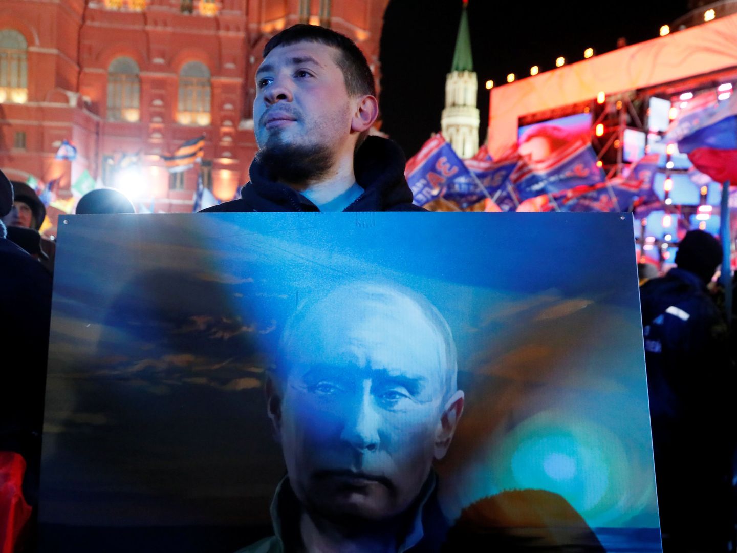Un opositor a Putin sostiene un póster del presidente ruso en Moscú, el 18 de marzo de 2018. (Reuters)