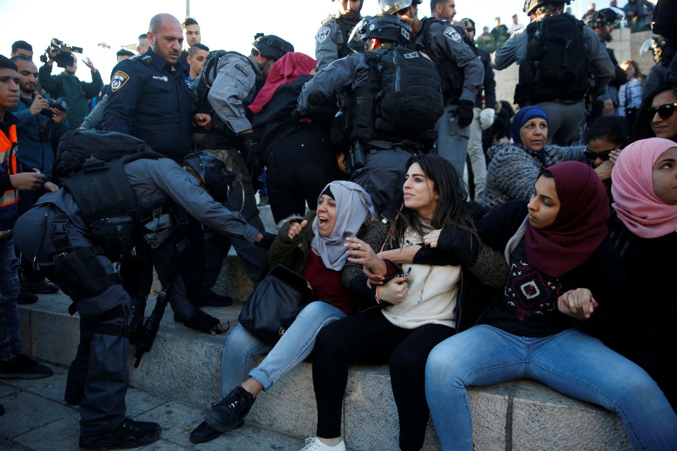 Un policía israelí en una refriega con una manifestante palestina en la Puerta de Damasco este viernes. (Reuters)