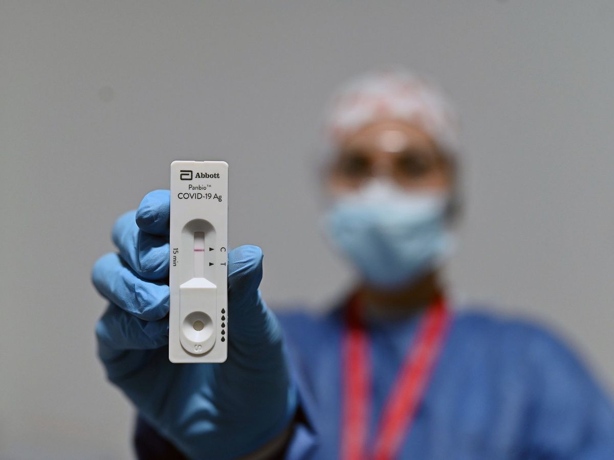 Foto: Una trabajadora sanitaria muestra un test de antígenos en la estación de Atocha en Madrid. (EFE/Fernando Villar)