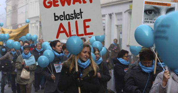 Foto: Un grupo de mujeres sostiene pancartas en las que se puede leer "La violencia nos afecta a todos", en Schwerin. (EFE) 