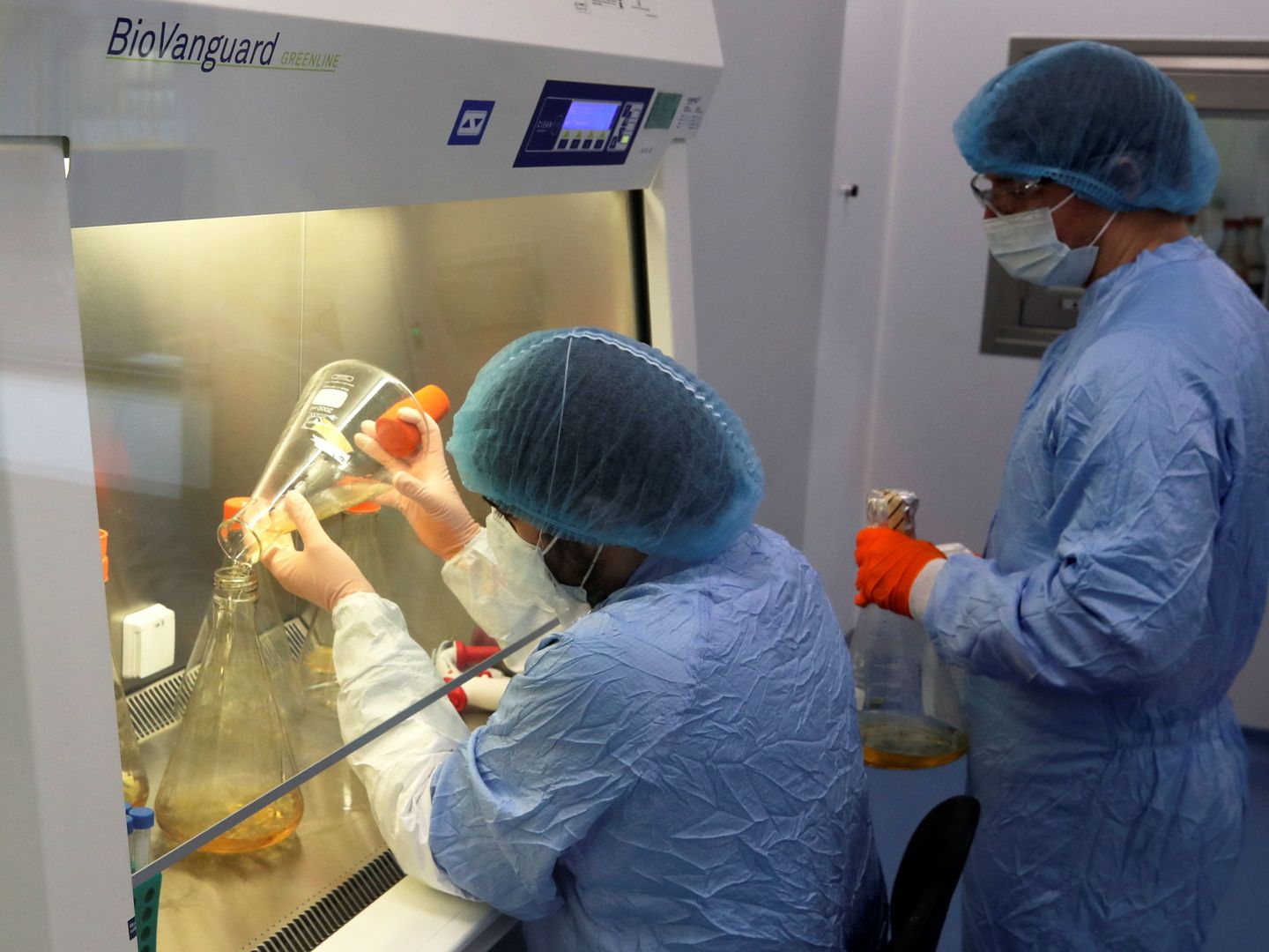 Operadores de laboratorio manipulan el ADN para una vacuna del covid en Bélgica. (Reuters)