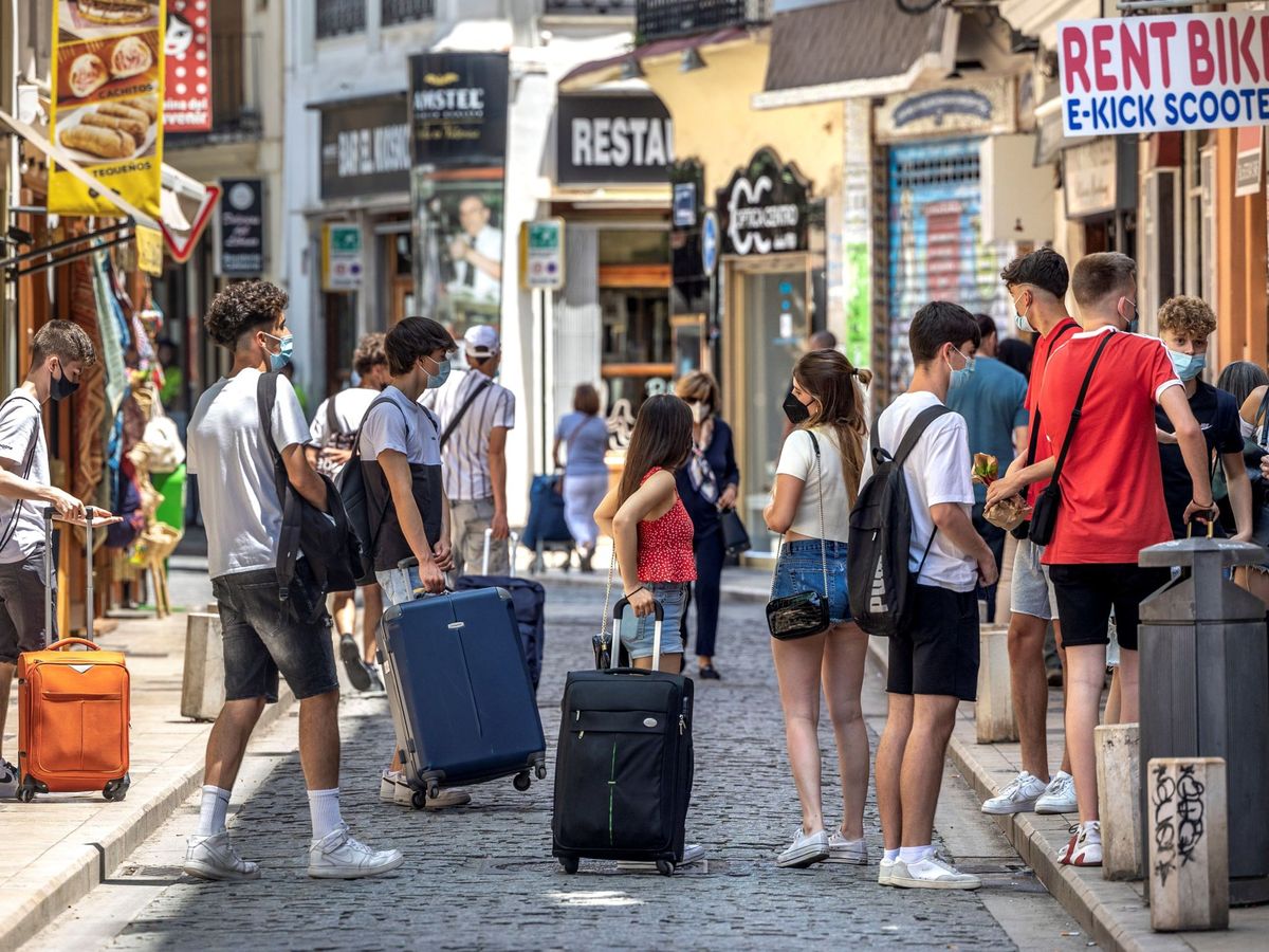 Foto: Gente esperando con sus maletas en Valencia. (EFE)