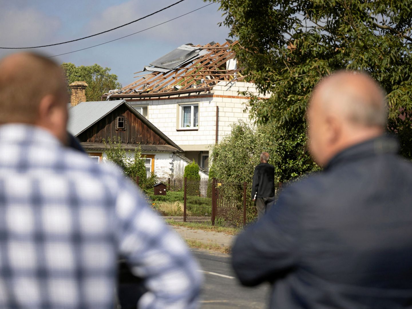 Varias personas observan los daños causados por uno de los drones derribados en la localidad polaca de  Wyryki (Reuters/Jakub Orzechowski)