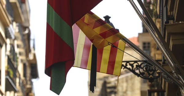 Foto: Una bandera catalana con crespón negro junto a una ikurriña en la puerta de una sociedad gastronómica de la Parte Vieja de San Sebastián. (EFE)
