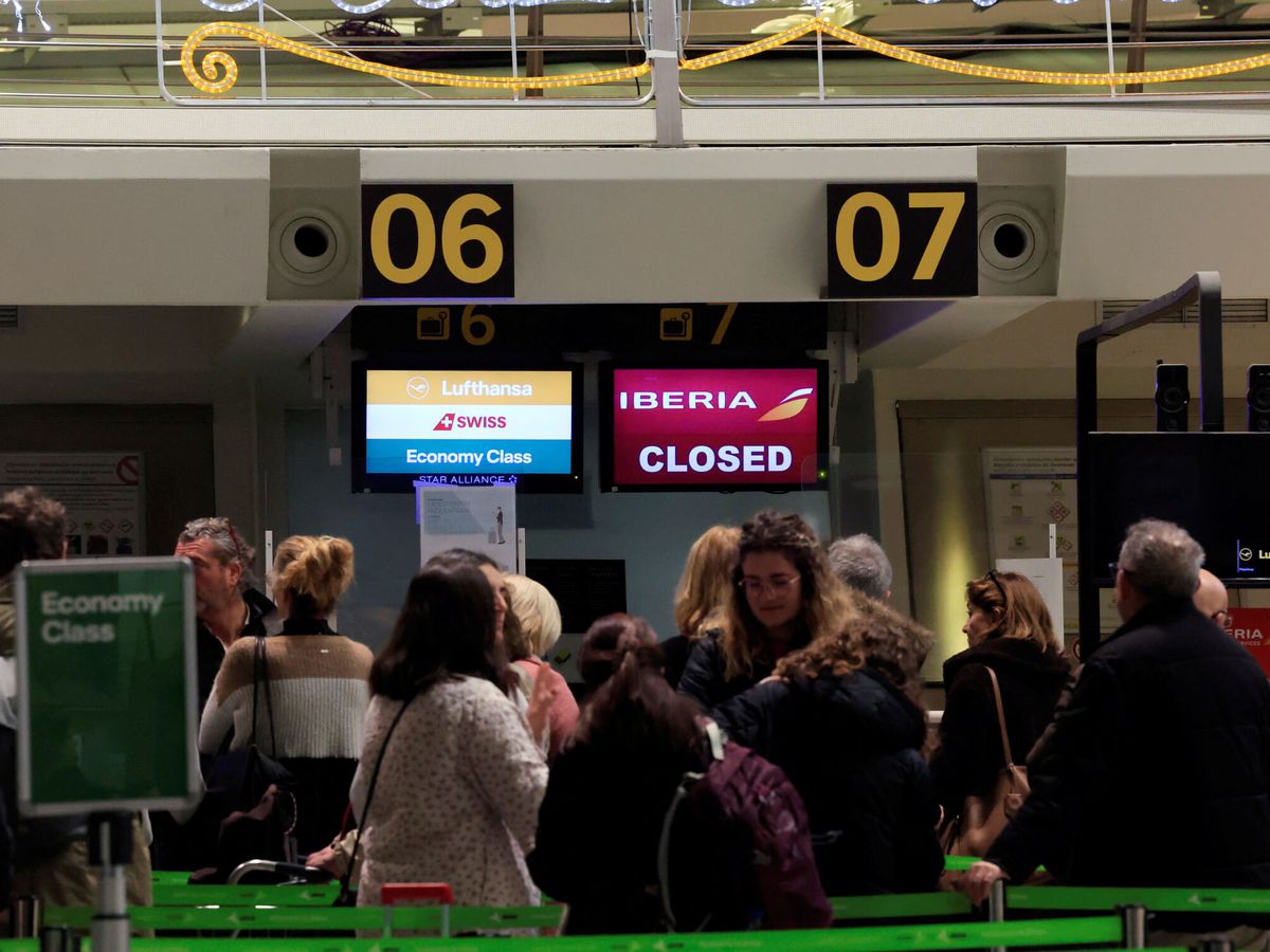 Foto: Los pasajeros observan un cartel de "cerrado" en el mostrador de facturación de Iberia en medio de la huelga del 'handling'. (Reuters/Vincent West)