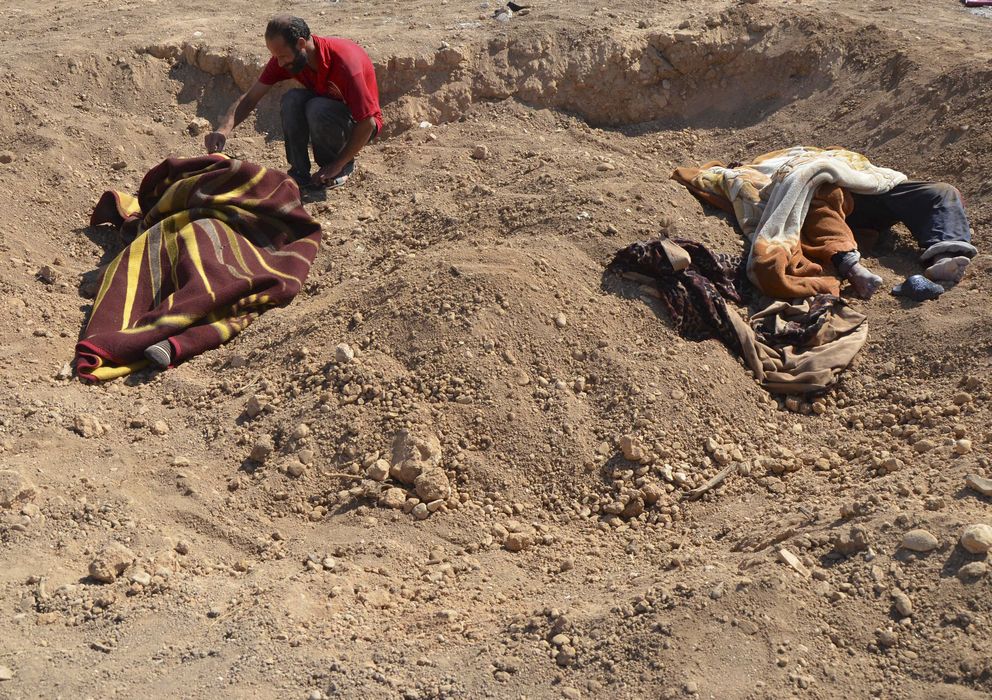 Foto: Un hombre junto a cadáveres de civiles víctimas del supuesto ataque tóxico en las cercanías de Damasco (Reuters).