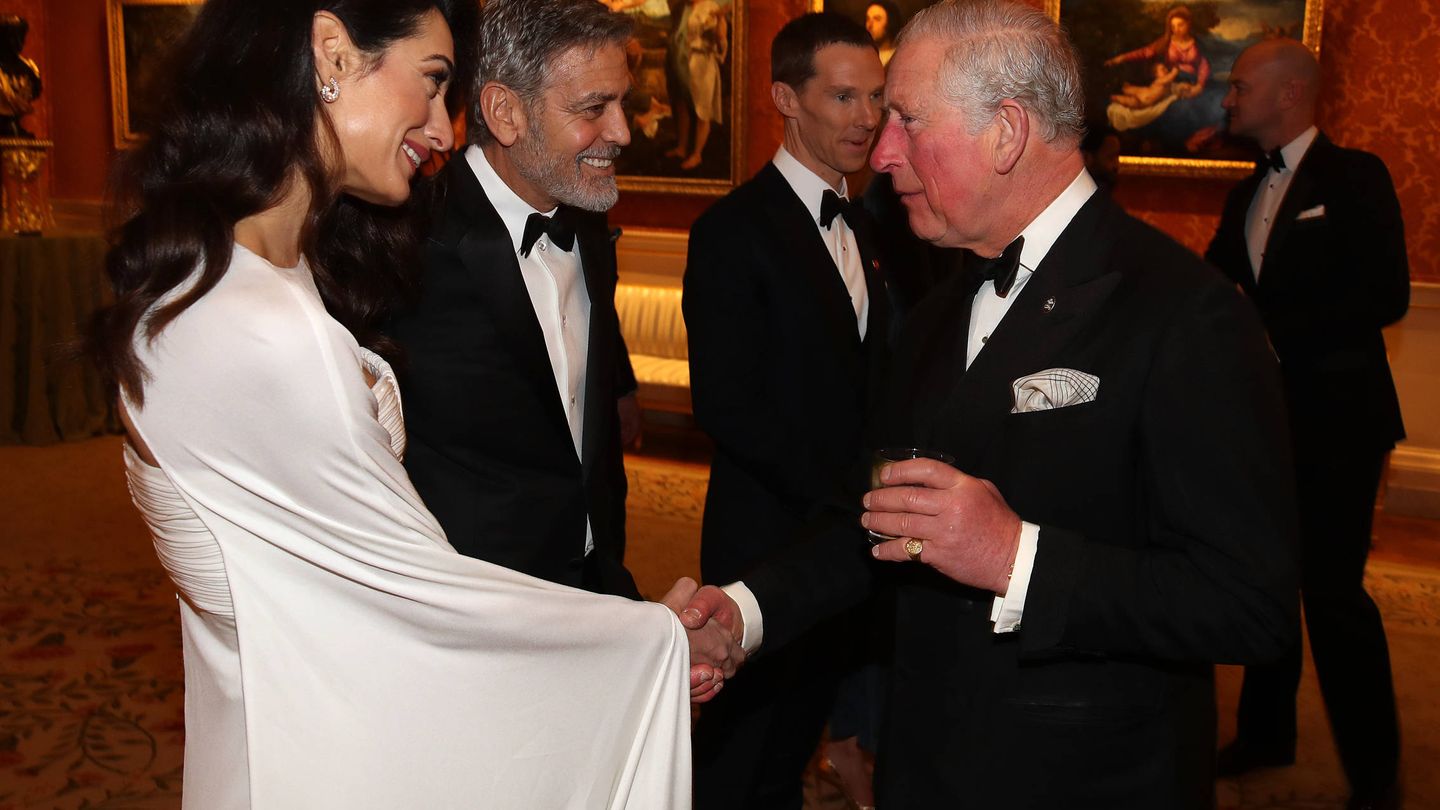Amal y George Clooney hablando con el príncipe de Gales durante la cena de The Prince's Trust. (Getty)