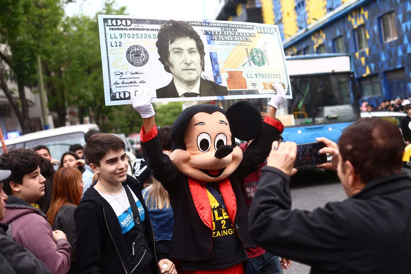 Una persona disfrazada sujeta una pancarta con la cara de Milei estampada en un dólar. (Reuters/Matias Baglietto)