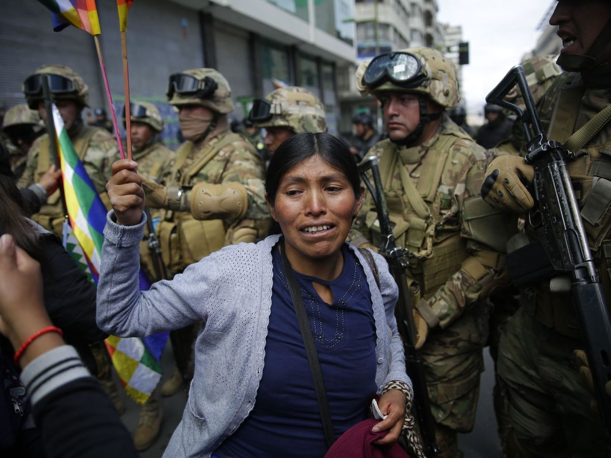 Foto: Indígenas y simpatizantes del expresidente Evo Morales bajo la vigilancia de policías, en La Paz (Bolivia). (EFE)