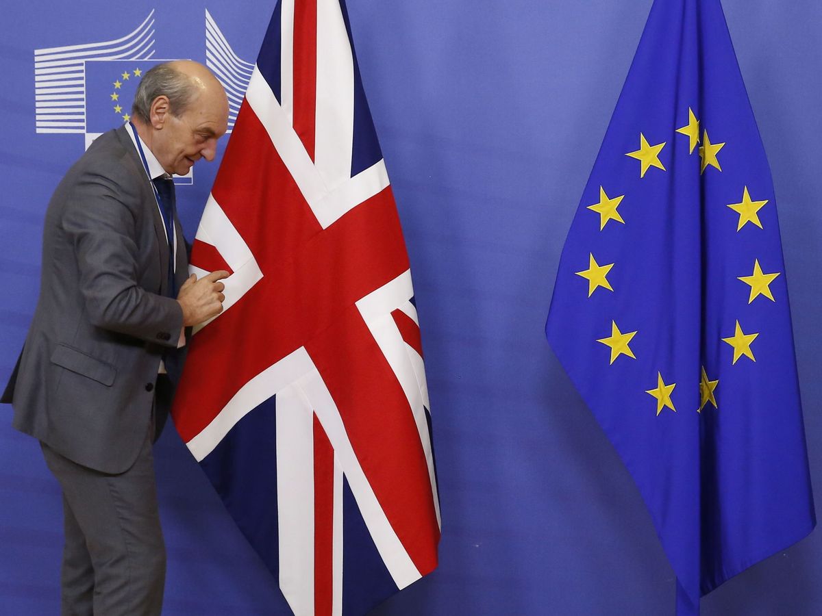 Foto: Un funcionario prepara la bandera británica junto a la europea para una reunión en 2018. (EFE)