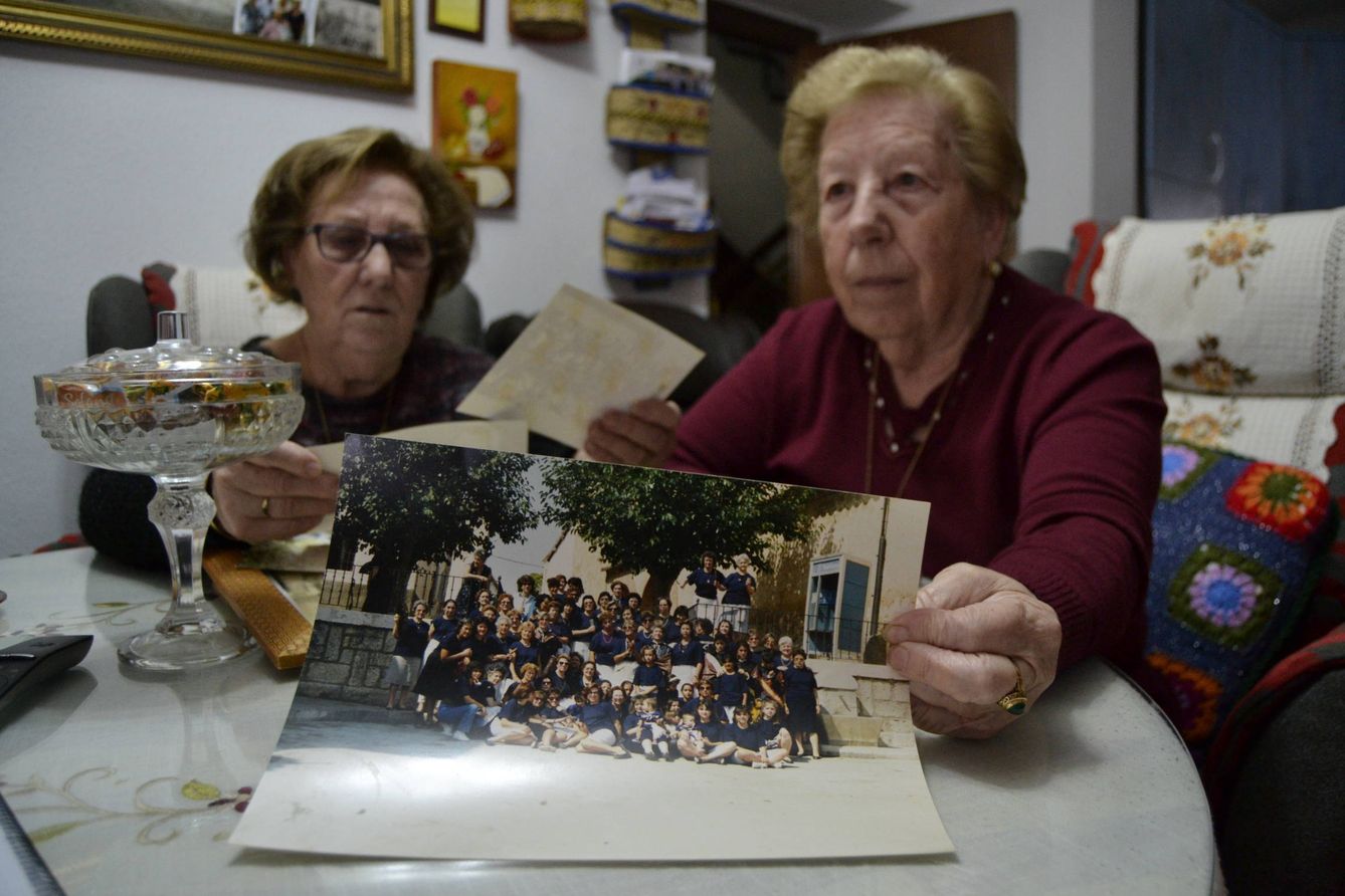 Julia y Teresa Lago, con una fotografía de cuando el pueblo pasaba épocas mejores. (M. Z.)