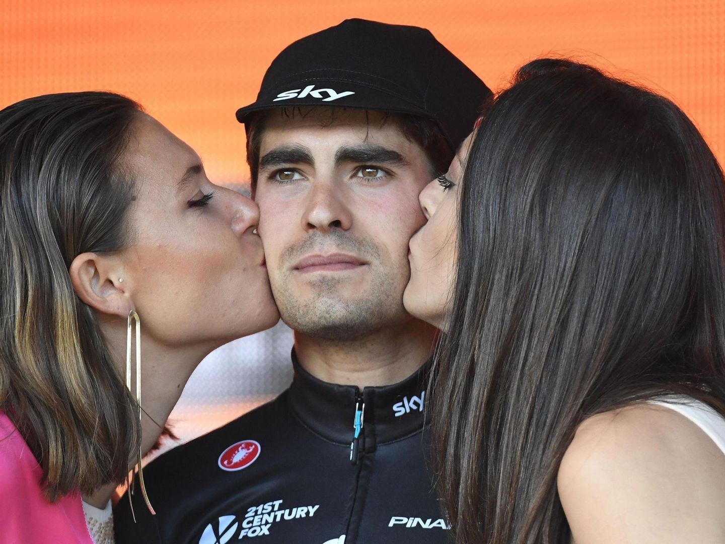 Mikel Landa es besado en el podio por dos azafatas del Giro de Italia. (EFE)