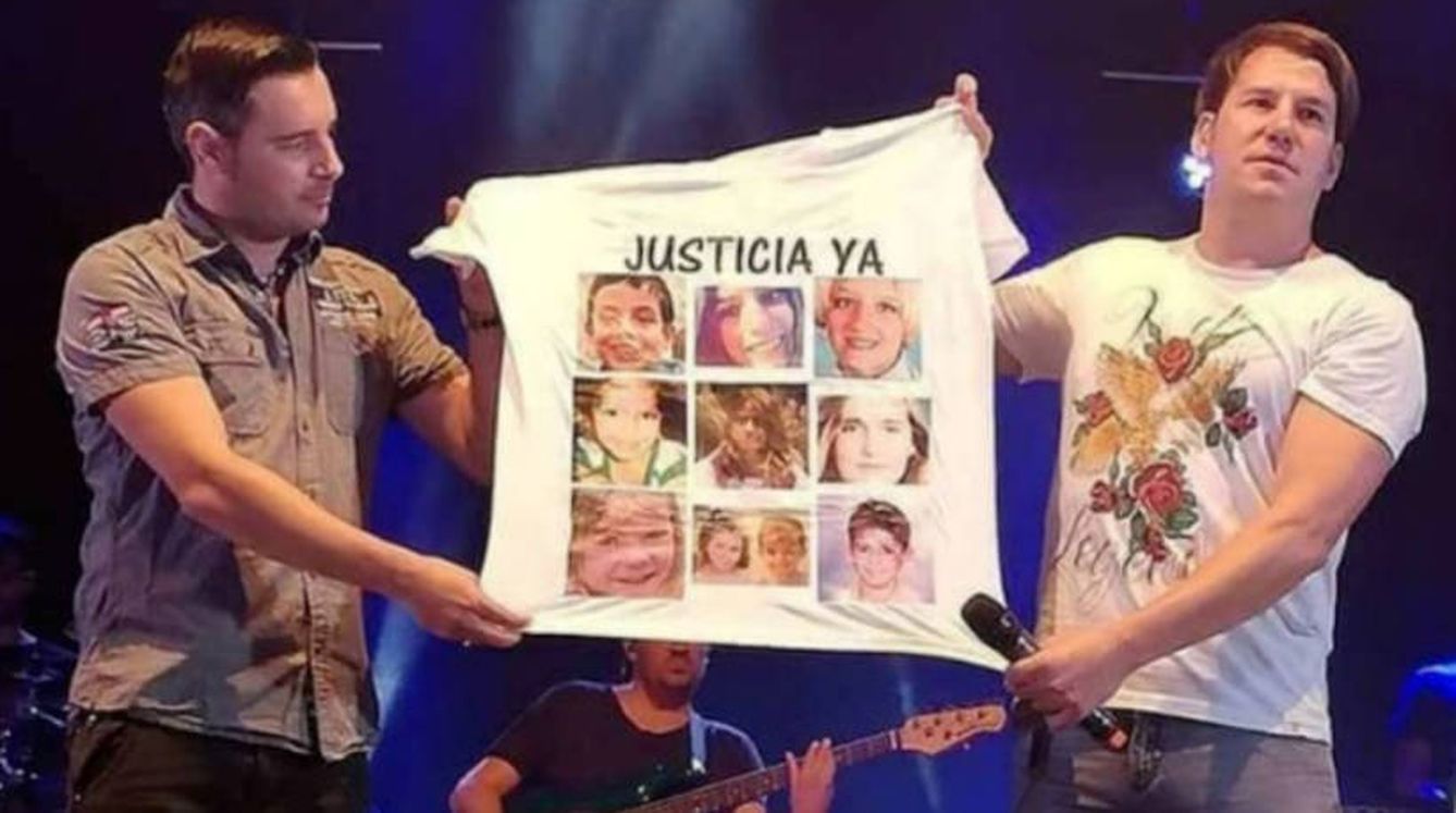 Andy y Lucas muestran una camiseta con la imagen de los niños asesinados durante un concierto. (Foto difundida por los padres de Gabriel)