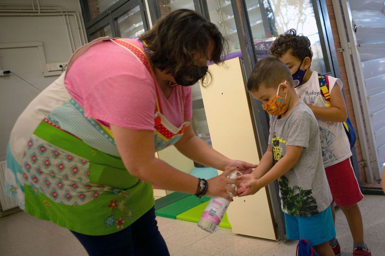 Una maestra desinfecta las manos de un alumno en un colegio de Barcelona. (EFE)