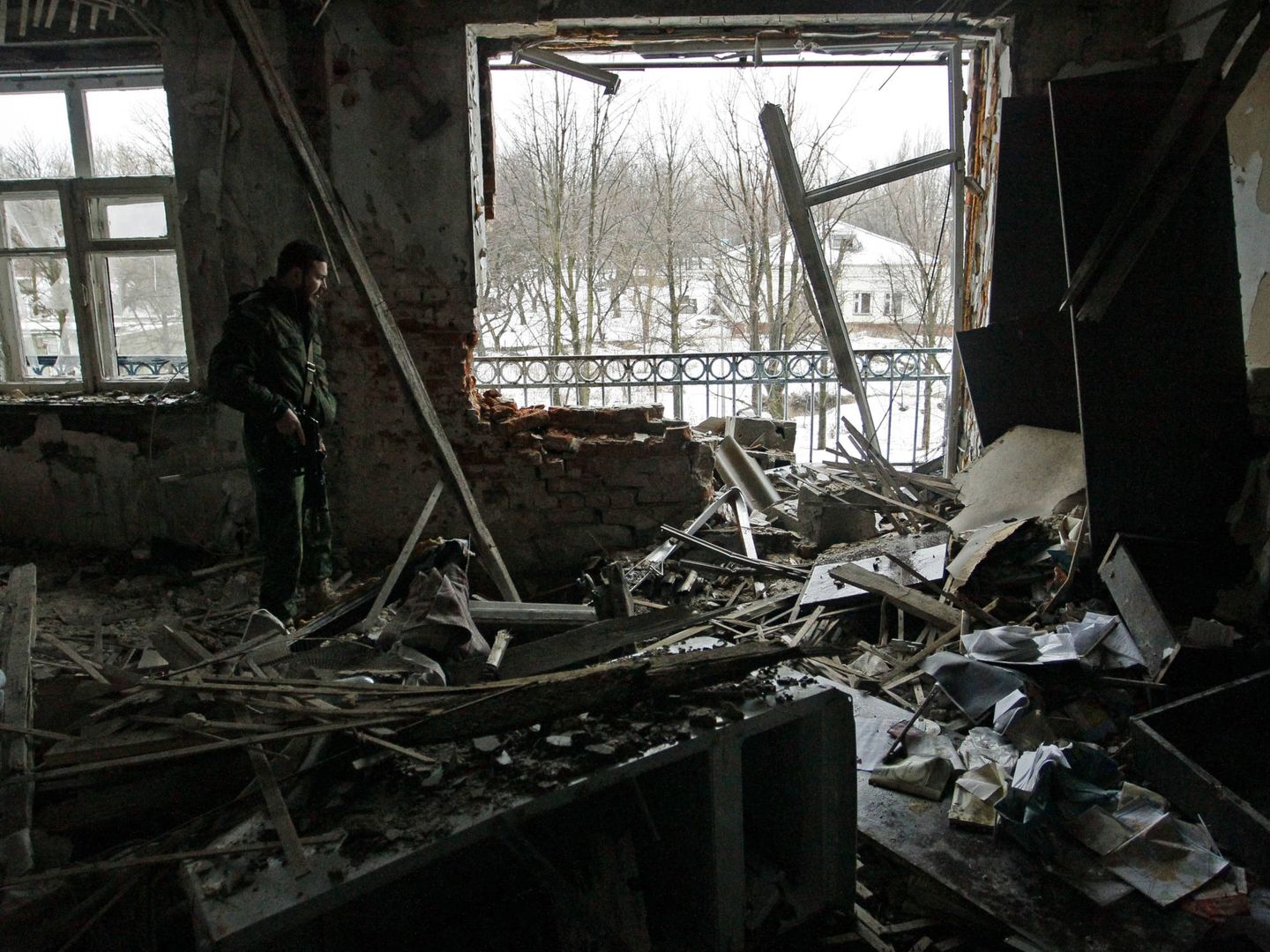 Un combatiente de la autoproclamada República Popular de Donetsk observa los daños provocados por los combates en una casa en Donetsk, Ucrania. (Reuters)