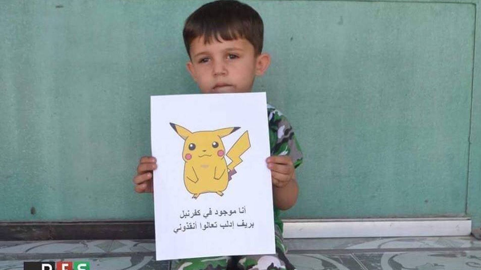 Foto: Un niño sirio sujeta un folio con un Pikachu dibujado para pedir ayuda. (RFS)