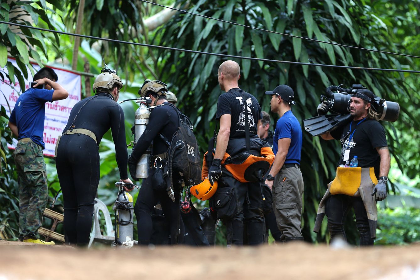 Buceadores tailandeses e internacionales transportan un equipo de inmersión hacia el interior de la cueva de Tham Luang. (Reuters)
