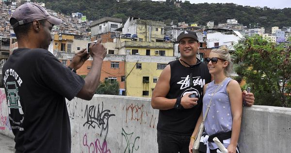 Foto: Dos turistas se fotografían en la favela Rocinha, la mayor de Brasil, donde se organizan 'tours' para extranjeros. (V. Saccone)