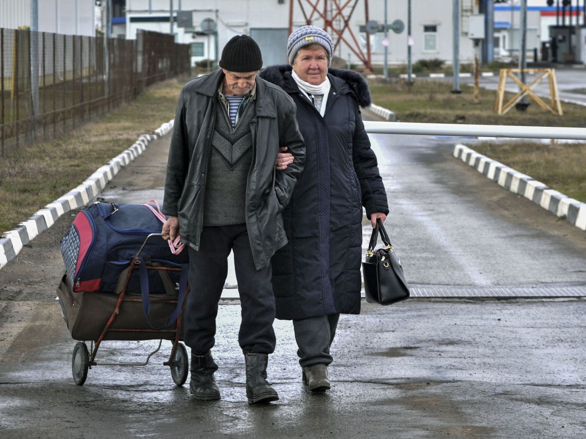 Foto: Dos refugiados cruzan la frontera de Ucrania con Rusia tras salir de Mariúpol. (EFE/EPA/Arkady Budnitsky)