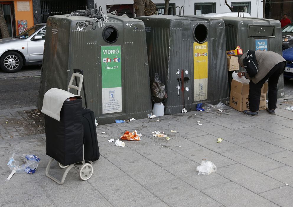 Foto: Un sin techo rebusca entre la basura en las calles de Madrid. (EFE)