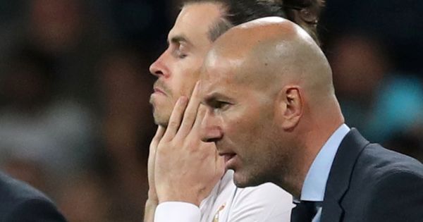 Foto: Bale, con gesto serio y los ojos cerrados, junto a Zidane en el momento de un cambio. (EFE)