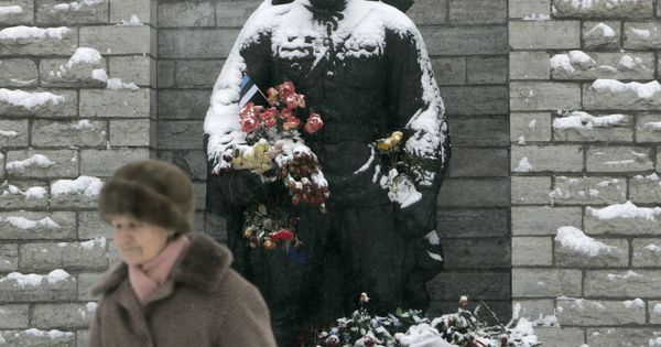 Foto: Una mujer pasa por delante de la Estatua del Soldado de Bronce antes de su retirada, en Tallin, febrero de 2007. (Reuters)