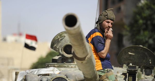 Foto: Un soldado del Ejército sirio leal a Bashar Al-Assad fuma sobre un tanque en Adra al-Omalia. (Reuters) 