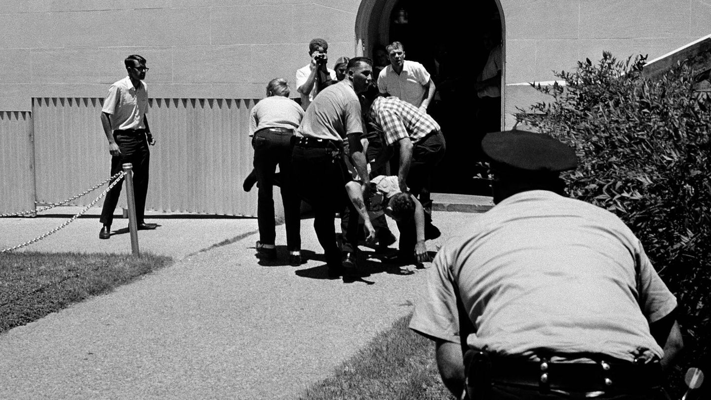 Un grupo de personas arrastra a un herido por los disparos desde la Torre de la Universidad de Texas