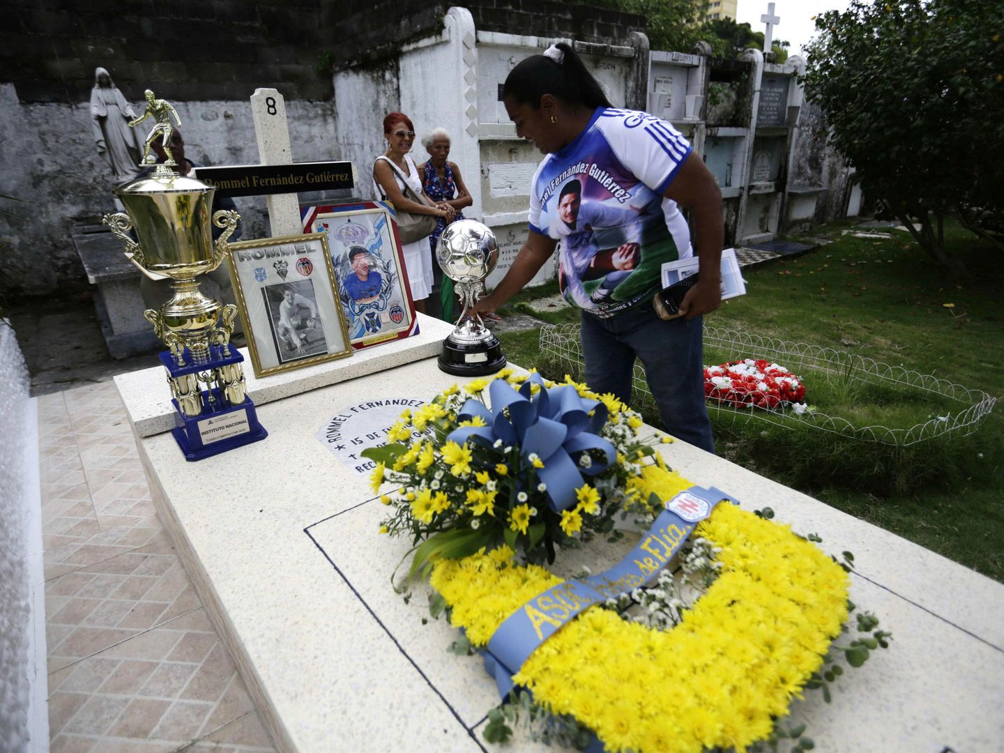 Familiares de Rommel Fernández visitan su tumba en el cementerio Amador. (EFE)