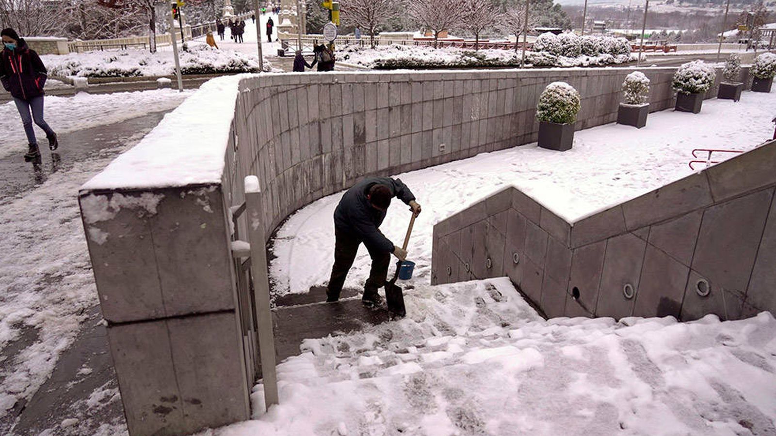 Un hombre quita la nieve helada de las escaleras en la ciudad de Teruel, que sufre los efectos del temporal Filomena. (EFE)