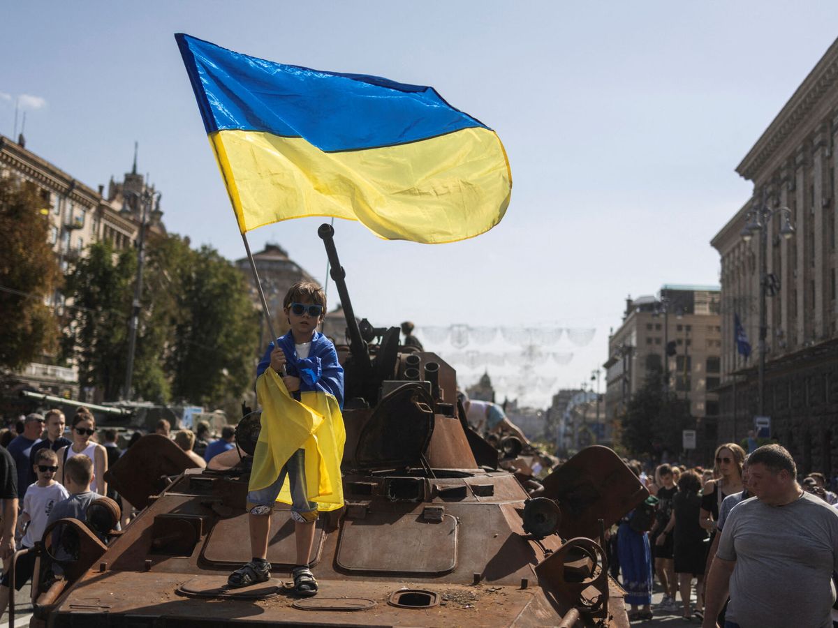 Foto: Un niño ondea la bandera nacional ucraniana en una exhibición de vehículos militares rusos destruidos en Kiev. (Reuters/Valentyn Ogirenko)