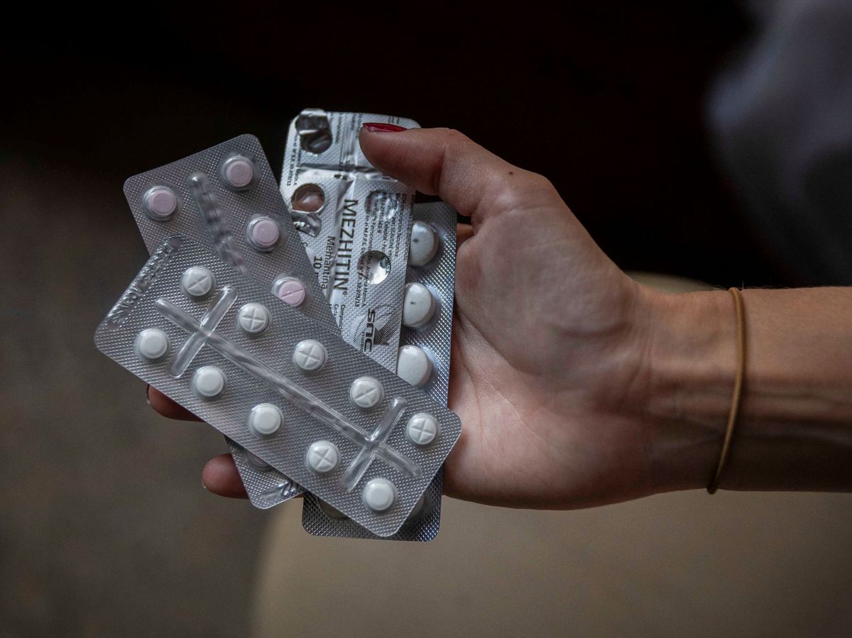 Foto: Una mujer sostiene medicamentos antipsicóticos, oxigenantes cerebrales y ansiolíticos. (EFE)