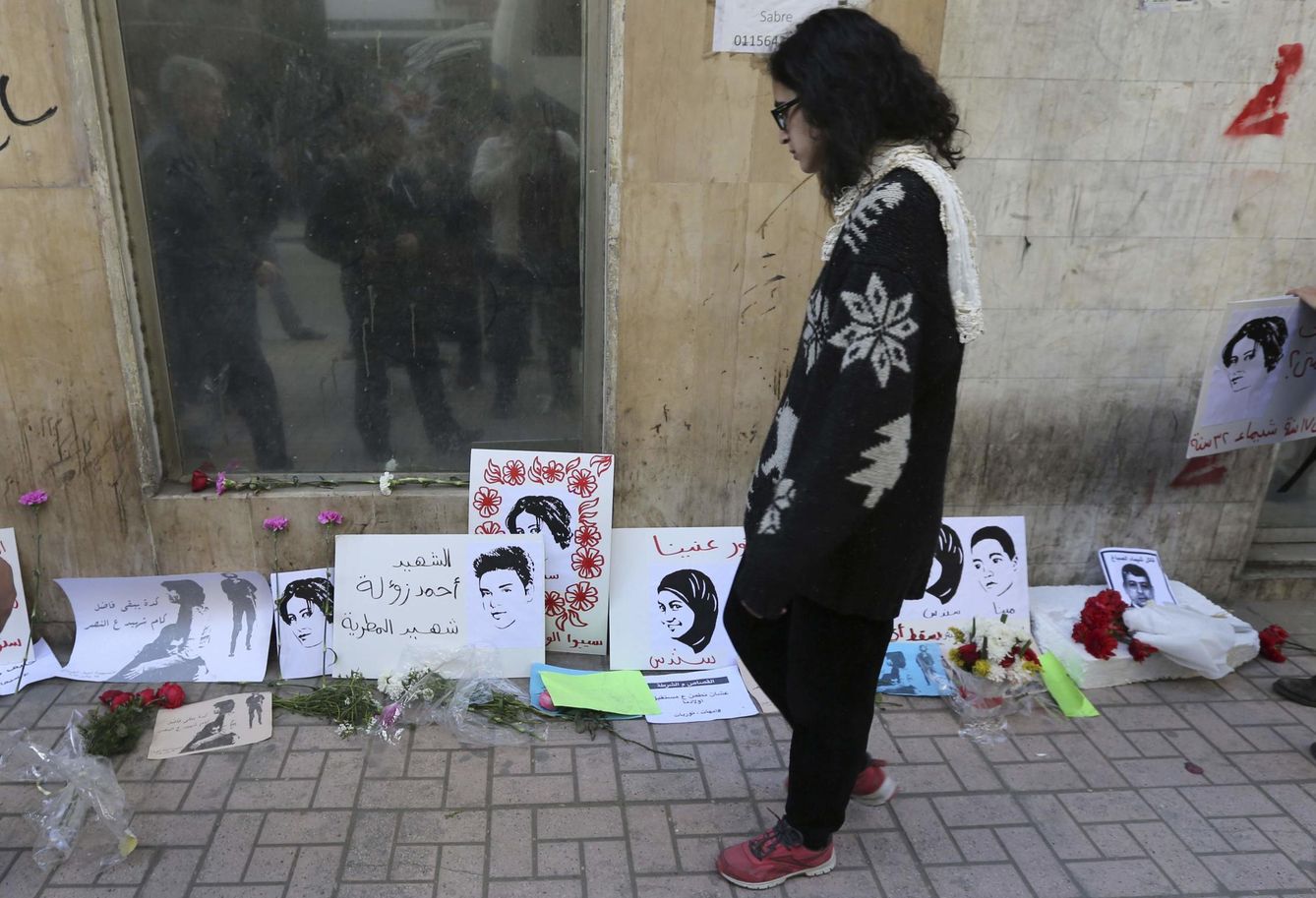 Una mujer observa los carteles de homenaje a la activista Shaimaa Sabbagh, asesinada de un tiro a quemarropa por la policía en El Cairo, en enero de 2015 (Reuters)